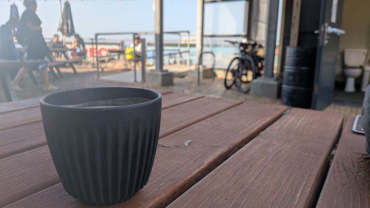 A cup of coffee on a bench.